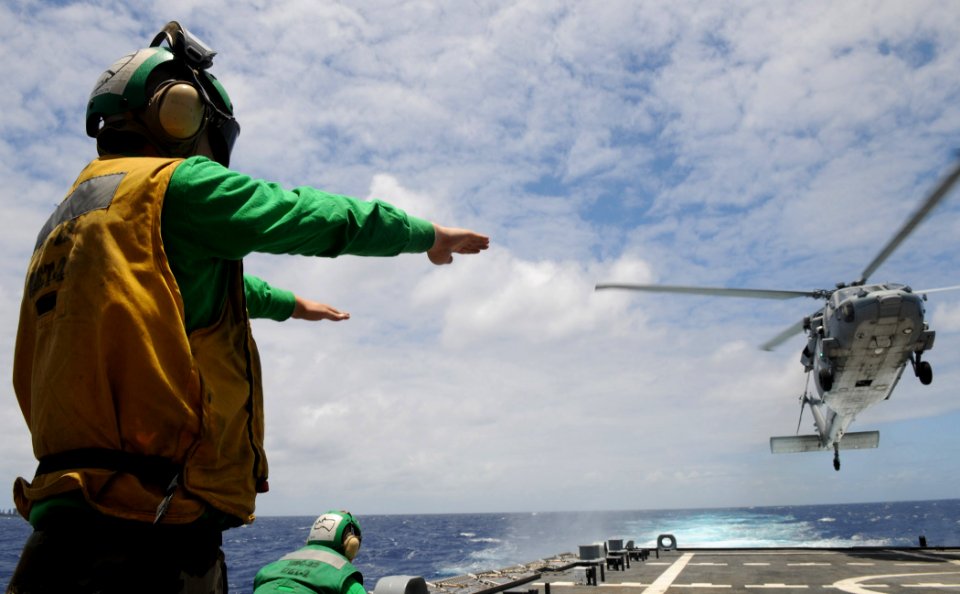 US Navy 100623-N-7058E-201 Aviation Structural Mechanic 3rd Class Nicholas Ellingson guides an SH-60 Sea Hawk helicopter to land aboard USS Freedom (LCS 1)