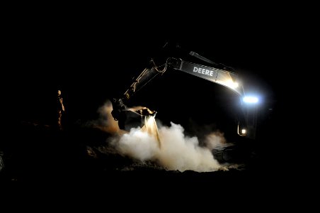US Navy 100624-N-0475R-578 Equipment Operator 3rd Class Kyle Kaumans, assigned to Naval Mobile Construction Battalion (NMCB) 5, guides an excavator