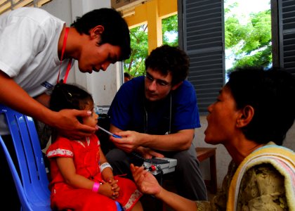 US Navy 100624-N-4044H-086 Philip Drennen, a medical student from New Zealand working at Phnom Penh Hospital, checks a child's temperature during a medical civic action event while the Military Sealift Command hospital ship USN