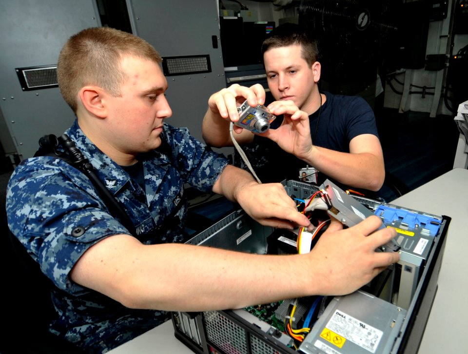 US Navy 100626-N-6003P-040 Information Systems Technicians 3rd Class Travis Golding and Michael Wentz take photographs for a manual on how to assemble computer towers