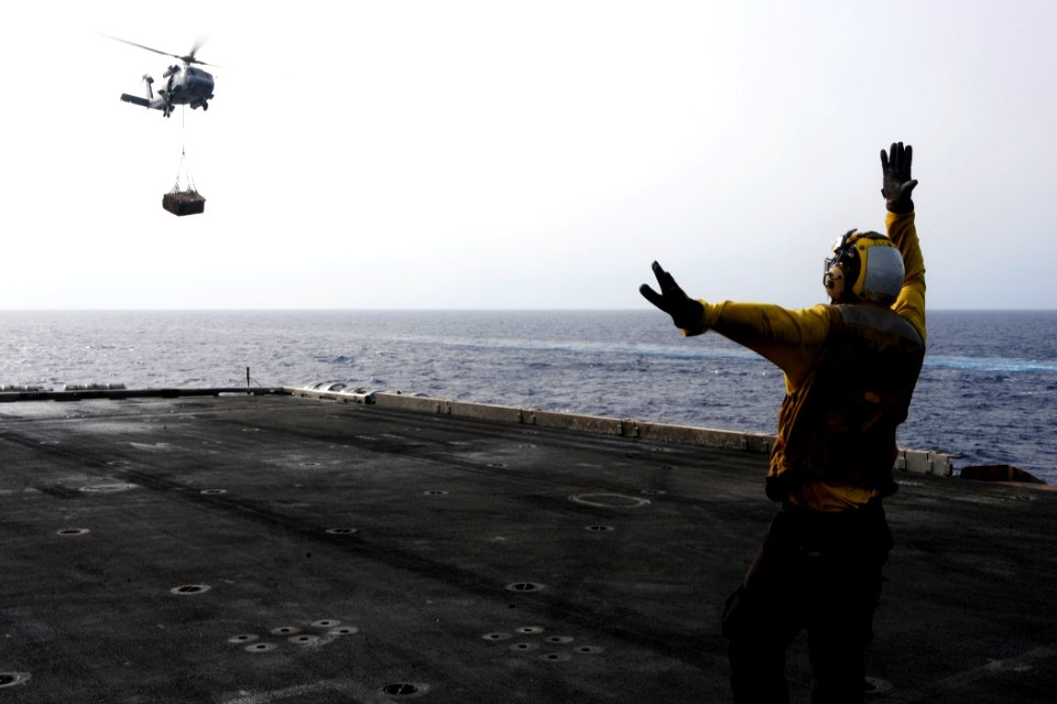 US Navy 100627-N-6604E-124 Aviation Boatswain's Mate (Handling) Airman Logan Crank directs the pilot of an SH-60F helicopter assigned to the Nightdippers of Helicopter Anti-submarine Squadron (HS) 5 during a vertical replenishm