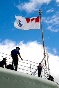 US Navy 100624-N-6674H-007 A Sailor aboard the Canadian Navy Iroquois-class guided-missile destroyer HMCS Algonquin (DDG 283) raises the ship's colors as the ship arrives at Joint Base Pearl Harbor Hickam for Rim of the Pacific