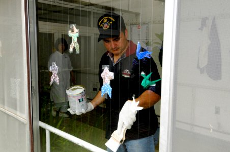 US Navy 100624-N-8335D-100 Fire Controlman 1st Class John Morrison paints a railing during a community service project