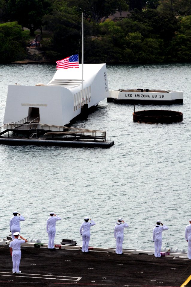 US Navy 100628-N-3659B-157 Sailors aboard the aircraft carrier USS Ronald Reagan (CVN 76) render honors as the ship passes by the battleship USS Arizona Memorial