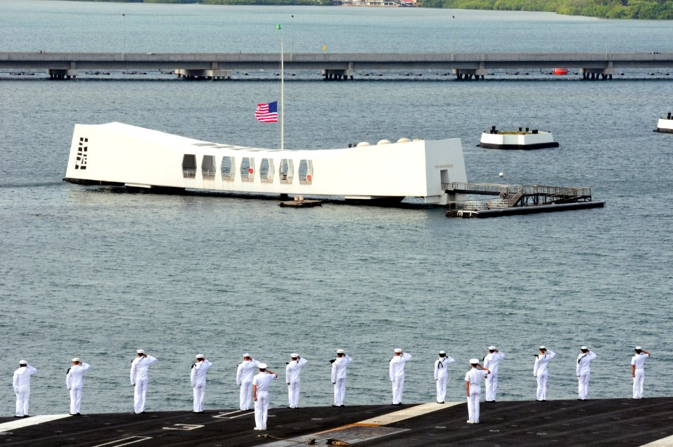 US Navy 100628-N-3659B-124 Sailors aboard the aircraft carrier USS Ronald Reagan (CVN 76) render honors as the ship passes by the battleship USS Arizona Memorial