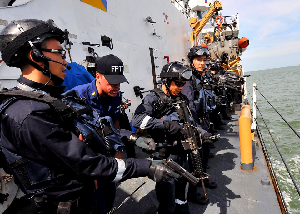 US Navy 100624-N-7643B-027 Chief Boatswain's Mate Foy Melendy checks to make sure a Singapore navy sailor's weapon is clear before starting a boarding exercise aboard the U.S. Coast Guard cutter (USCGC) Mellon (WHEC 717)