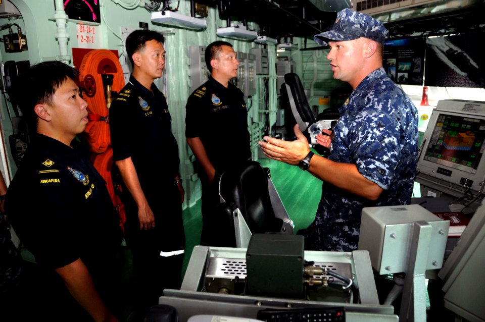 US Navy 100628-N-7498L-077 Chief Damage Controlman Craig Cole, assigned to the littoral combat ship USS Freedom (LCS 1), gives a tour of ship's bridge to a group of Singapore sailors from the Republic of Singapore Navy frigate