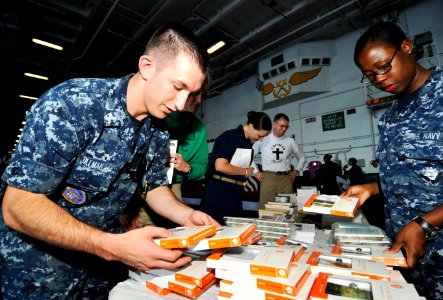 US Navy 100625-N-6003P-013 Aviation Structural Mechanic 2nd Class Anthony Ullman looks through audio books at the Command Religious Ministries booth