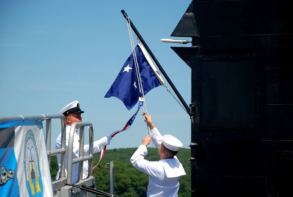 US Navy 100625-N-3090M-255 Electronics Technician 1st Class Nicholas Harr lowers the commissioning pennant during the submarine's decommissioning ceremony