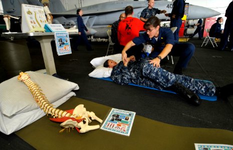 US Navy 100625-N-6003P-001 Cmdr. Denise Milton, command physical therapist, shows Information Systems Technician 3rd Class Krystal Landrove stretching exercises during a mind, body and spirit campaign