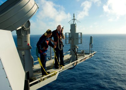 US Navy 100626-N-4830B-077 Sailors ommunicate with a safety observer as they perform maintenance on the OE-82 antenna on the yardarm aboard the aircraft carrier USS George Washington (CVN 73)