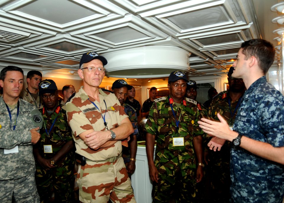 US Navy 100629-N-4236E-558 Mass Communication Specialist 2nd Class John Herman, right, explains the history of the Nimitz-class aircraft carrier USS Dwight D. Eisenhower (CVN 69)