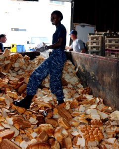US Navy 100626-N-9634R-134 Seaman Fridah N. Kelley wades through a dumpster of expired bread that will be given to local farmers to use as compost during a community service project at the Feed Nova Scotia food bank photo