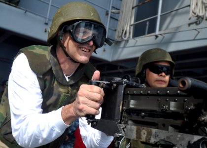 US Navy 100630-N-2013O-342 Capt. David Lausman, commanding officer of the aircraft carrier USS George Washington (CVN 73), fires an M2 .50-caliber machine gun