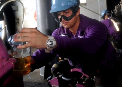 US Navy 100630-N-2013O-088 Aviation Boatswain's Mate (Fuel) Airman Victor Hopkins, from Glen Burnie, Md., collects a sample of JP-5 jet fuel for analysis aboard the aircraft carrier USS George Washington (CVN 73)