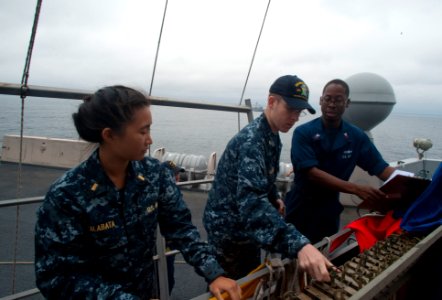 US Navy 100701-N-5319A-030 Quartermaster 1st Class Martez Smith instructs Ensigns Jessica Alabata and Andrew Norris how to raise signal flags during flag signaling drills