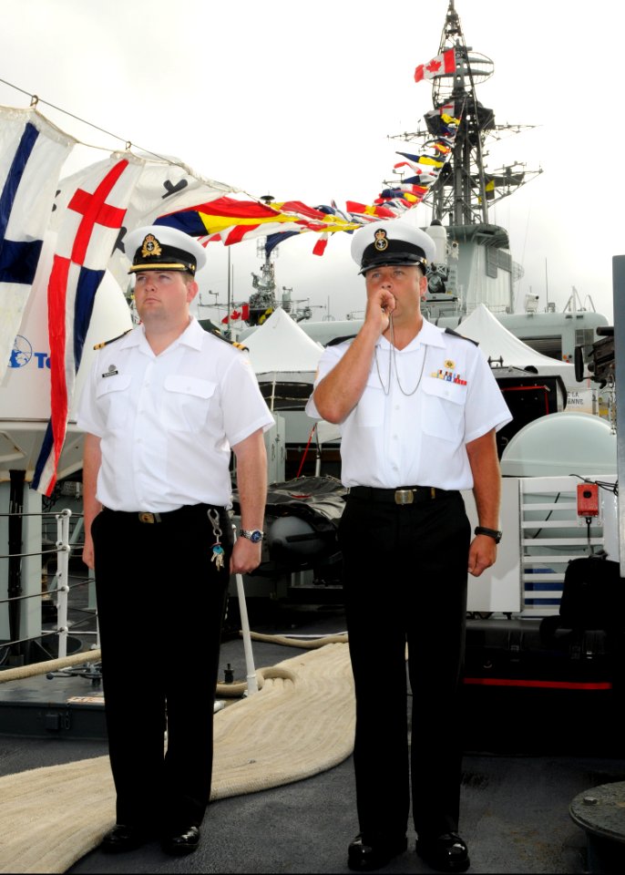 US Navy 100701-N-8539M-074 Lt. Les Gunderson and Leading Seaman Pierre Ouellet participate in a morning colors ceremony aboard the Royal Canadian Navy destroyer HMCS Algonquin (DDG 283)