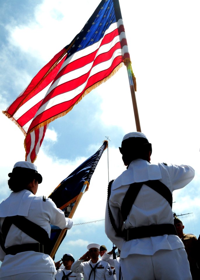 US Navy 100702-N-5148B-012 Service members salute the U.S. flag aboard the USS Midway Museum during a military naturalization ceremony