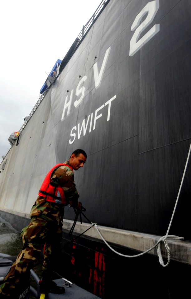 US Navy 100629-N-9643W-108 An El Salvadorian sailor moors a rigid-hull, inflatable boat boat to High Speed Vessel Swift (HSV 2)