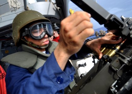 US Navy 100630-N-2013O-221 Aviation Ordnanceman Airman Jarel Taylor, from Lynchburg, Va., reloads an M2 .50-caliber machine gun during a .50-caliber qualification shoot aboard the aircraft carrier USS George Washington (CVN 73)