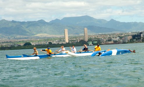 US Navy 100630-N-7200S-091 An outrigger canoe team passes the overturned canoe of the outrigger canoe team from the Republic of Singapore Navy frigate RSS Supreme (70)