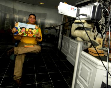 US Navy 100705-N-4135M-077 Lt. Cmdr. Eugene Trelles, from Ft. Myers, Fla., reads a book to his three-year old twins while participating in the United Through Reading program
