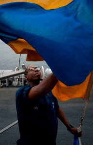US Navy 100701-N-5319A-018 Quartermaster 1st Class Martez Smith lowers a signal flag during signaling drills