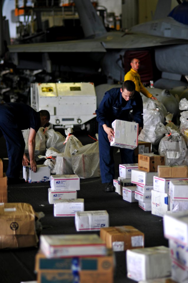 US Navy 100706-N-6362C-188 Cryptologic Technician Seaman Apprentice Steven Oleyourrk moves boxes of mail in the hangar bay aboard the aircraft carrier USS Harry S. Truman (CVN 75)
