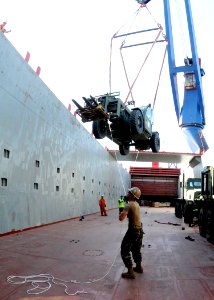 US Navy 100701-N-6357K-007 A Seabee assigned to Naval Mobile Construction Battalion (NMCB) 7 assists a civilian crane crew with the loading of civil engineering support equipment transport to the detail's operating site in Sao