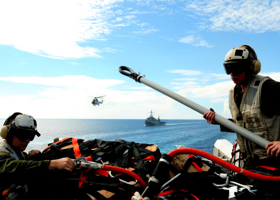 US Navy 100707-N-1226D-373 Marines assigned to combat cargo, 15th Marine Expeditionary Unit (15th MEU), remove a net from cargo that was delivered from the Military Sealift Command dry cargo and ammunition ship USNS Amelia Earh