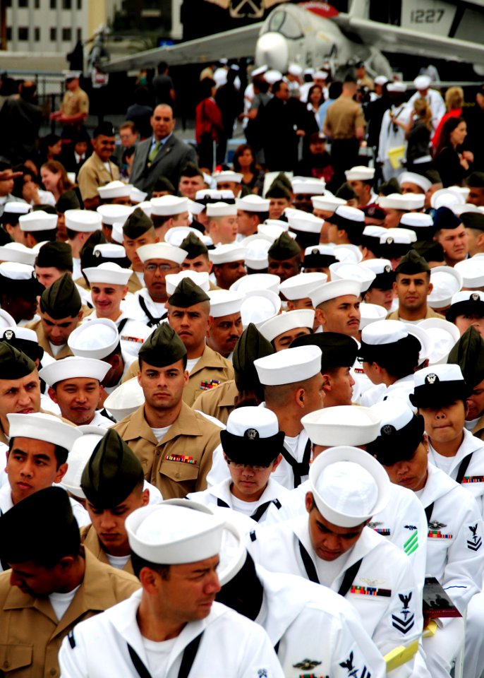 US Navy 100702-N-5148B-095 hree hundred Sailors, Marines, Soldiers, Airmen and Coast Guardsmen from more than 50 countries stand on the flight deck aboard the USS Midway Museum, awaiting their final step in the process of becom