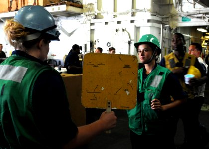 US Navy 100707-N-2908M-046 Boatswain's Mate 3rd Class Danielle Thorne gives training on proper signaling for a replenishment at sea to Boatswain's Mate Seaman Afton Patrick aboard USS Kearsarge (LHD 3)