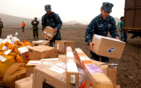 US Navy 100703-N-5319A-030 Logistics Specialist 2nd Class Julius Green, left, and Logistics Specialist 3rd Class Claudia Morales stack mail to be delivered to the amphibious transport dock ship USS New Orleans (LPD 18)