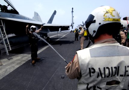 US Navy 100703-N-4135M-366 Cmdr. Edward Heflin, Officer of the Swordsmen of Strike Fighter Squadron (VFA) 32 is sprayed down on the flight deck of the aircraft carrier USS Harry S. Truman (CVN 75) after a change of command cere