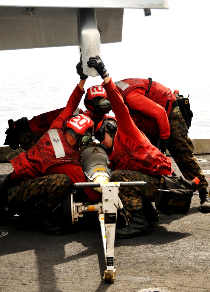 US Navy 100707-N-6362C-132 Ordnancemen assigned to the Checkerboards of Marine Fighter Attack Squadron (VMFA) 312 load a GBU-38 Joint Direct Attack Munitions bomb to an F-A-18C Hornet