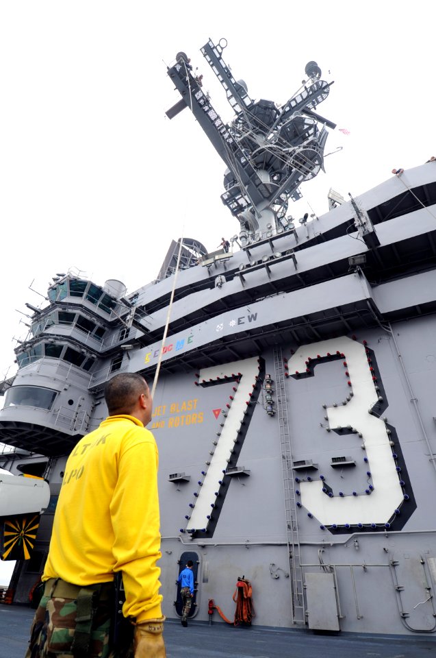 US Navy 100703-N-7191M-010 Aviation Boatswains Mate (Handling) 1st Class Andres Bonilla from Miami Beach, Fla., holds an up and over line in preparation for decorating the aircraft carrier USS George Washington (CVN 73) for the