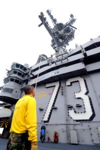 US Navy 100703-N-7191M-010 Aviation Boatswains Mate (Handling) 1st Class Andres Bonilla from Miami Beach, Fla., holds an up and over line in preparation for decorating the aircraft carrier USS George Washington (CVN 73) for the