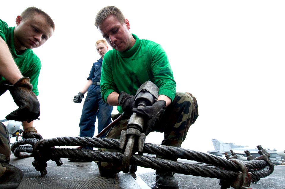 US Navy 100703-N-7191M-030 Aviation Boatswain's Mate (Equipment) 2nd Class Michael Vertrees from Elizabethtown, Ky. de-torques the arresting gear purchase cable on the flight deck aboard the aircraft carrier USS George Washingt