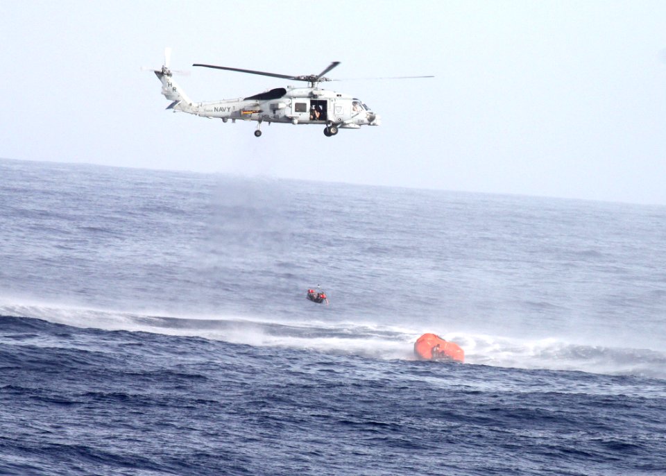 US Navy 100705-N-4091C-023 A SH-60B Sea Hawk helicopter, assigned to the guided-missile frigate USS Elrod (FFG 55), hovers above a life raft while performing a search and rescue operation