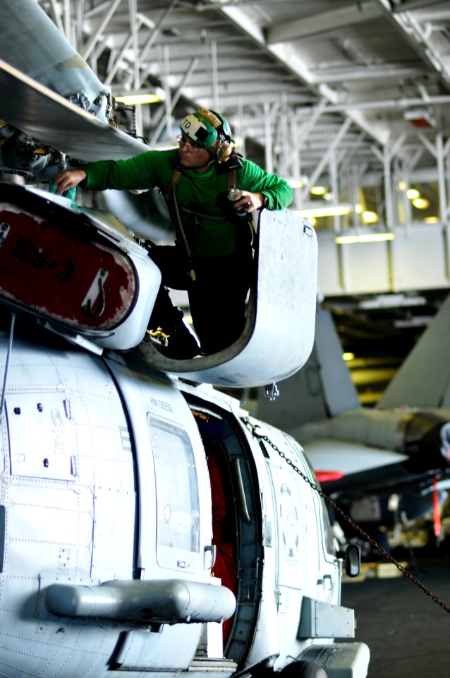 US Navy 100706-N-6362C-069 Aviation Machinist's Mate 2nd Class Dwayne Hartman performs an inspection on an SH-60F Sea Hawk helicopter