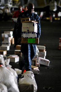 US Navy 100706-N-6362C-240 Machinist's Mate Fireman Tyler Jones carries newly received packages to distribute in his division aboard the aircraft carrier USS Harry S. Truman (CVN 75)