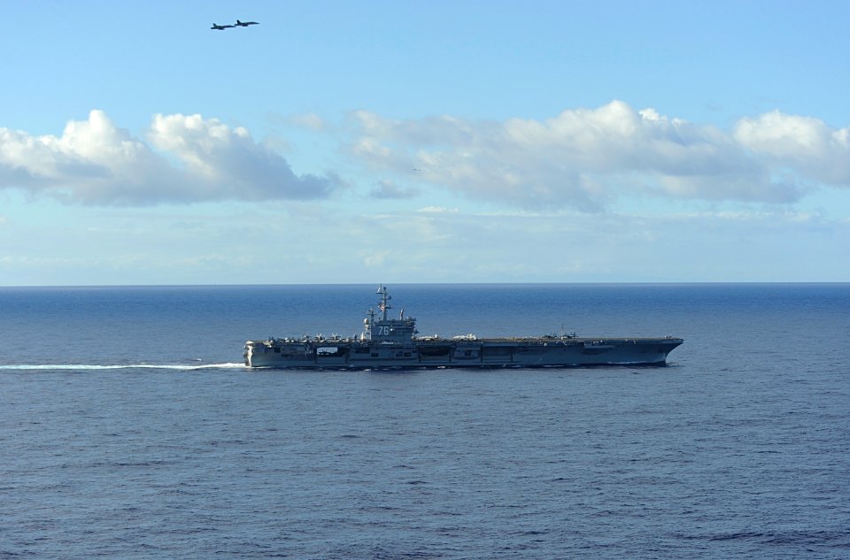 US Navy 100706-N-9500T-598 Two F-A-18 Hornets fly over USS Ronald Reagan (CVN 76) after she departed Pearl Harbor to participate in Rim of the Pacific (RIMPAC) 2010 exercises