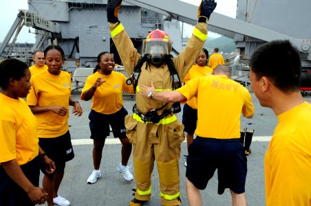 US Navy 100709-N-8335D-913 A Sailor checks the firefighting ensemble of his teammate during a damage control Olympics relay race