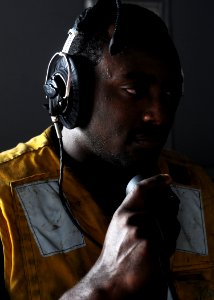 US Navy 100707-N-2908M-006 Boatswain's Mate 1st Class Marquell Mccoy checks the sound powered phone to insure clear communication with other stations before a replenishment at sea aboard USS Kearsarge (LHD 3)