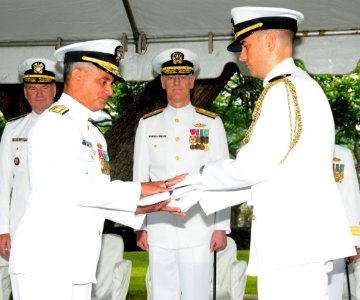 US Navy 100709-N-3666S-026 A Sailor presents Rear Adm. Michael Giorgione with a flag during a change of command ceremony at Commander, U.S. Pacific Fleet Headquarters photo