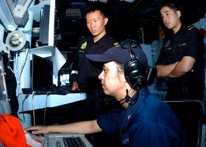 US Navy 100711-N-0995C-050 Republic of Singapore navy officers observe Operations Specialist 2nd Class Jessica Proudfoot track contacts during an anti-submarine warfare exercise aboard the guided-missile destroyer USS Chung-Hoo