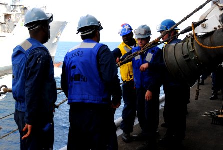 US Navy 100707-N-7948R-242 Sailors aboard the amphibious dock landing ship USS Pearl Harbor (LSD 52) put tension on a spanning wire during replenishment at sea