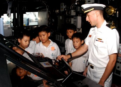 US Navy 100708-N-0995C-052 Lt. j.g. Chris Malta, electrical officer aboard the guided-missile cruiser USS Princeton (CG 59), explains the lee helmsman watch to students from a Singaporean elementary school
