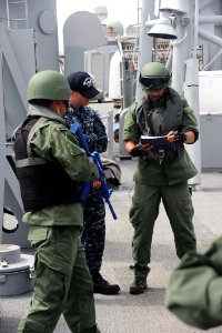 US Navy 100710-N-7200S-106 Ensign Corey Spuhler speaks with the Korean visit board search and seizure team while participating in training evolutions aboard USS McClusky (FFG 41)