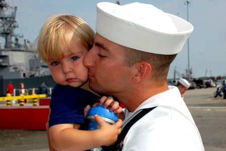 US Navy 100708-N-5292M-614 Fire Controlman 2nd Class Orry Coriell, assigned to the guided-missile cruiser USS Vella Gulf (CG 72), kisses his 18-month-old son good-bye photo